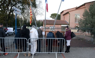 Des habitants signent le livre de condoléances devant la mairie de Saint-Feliu d'Avall, le 15 décembre.