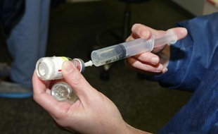 Une infirmière anesthésiste pompe un produit anesthésiant à l'aide d'une seringue, le 23 décembre 2002