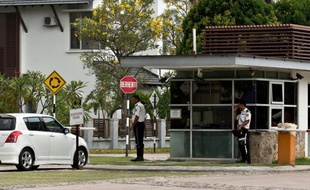 Des gardes à l'entrée du complexe résidentiel où habite le pilote Zahari Ahmad Shah, le 16 mars 2014 à Shah Alam près de Kuala Lumpur