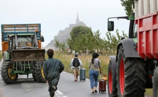 Des touristes passent les barrages des agriculteurs à pied pour se rendre le 21 juillet 2015 au Mont-Saint-Michel