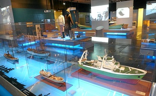 Des maquettes de bateaux et des tenues de pêcheurs sont exposées.