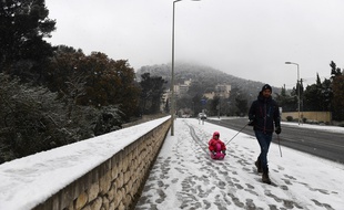 Un homme promène un enfant sur une luge à Marseille, le 2 décembre.