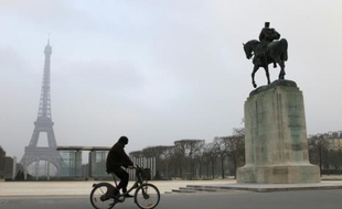 Un cycliste passe près de la Tour Eiffel à Paris
