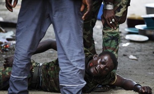 Un ancien membre des forces pro-Gbagbo entre les mains des hommes fidèles à Ouattara à Abidjan le 16 avril 2011.