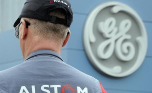 Un employé d'Alstom devant le logo de General Electric, le 28 avril 2014 à Belfort dans le nord-est de la France