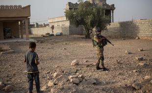 Un soldat des forces spéciales avec un enfant dans la banlieue de Mossoul le 5 août 2016.