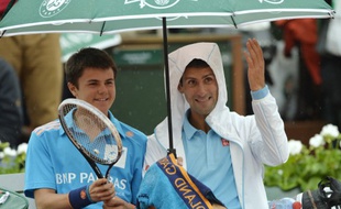 Le Serbe Novak Djokovic avec un ramasseur de balle, le 26 mai 2014, à Roland-Garros.