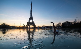 A man swims in the frozen water of the Trocadero fountain in front Eiffel Tower, on January 6, 2017 in Paris. / AFP PHOTO / OLIVIER MORIN