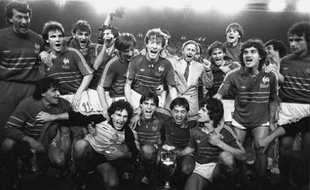 Les joueurs de l'équipe de France posant autour du trophée de l'Euro 1984, après une victoire en finale face à l'Espagne (2-0), le 27 juin 1984, au Parc des Princes, à Paris.