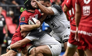 Les piliers toulousains Clément Castets et Charlie Faumuina plaquent le troisième ligne de Lyon Liam Gill, le 1er septembre 2019 en Top 14.