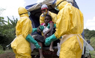 Du personnel de la Croix Rouge française transport un malade atteint par Ebola près de la ville guinéenne de Macenta le 21 novembre 2014