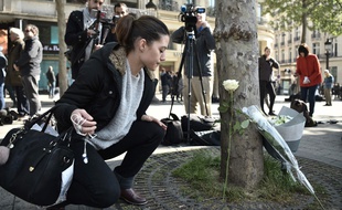 Sur les Champs-Elysées vendredi 21 avril 2017, certains passants déposent des fleurs à l'endroit où un policier a été tué.