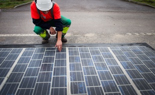 Un ingénieur teste un panneau photovoltaïque posé sur une route (Illustration).