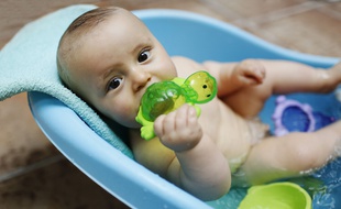Un bébé prend son bain. Illustration.