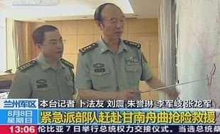Deux militaires chinois montrent la provine de Gansu où un glissement de terrain a fait au moins 96 morts, dimanche 8 août.
