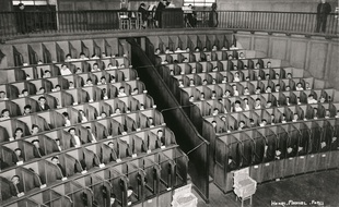 Détenus dans les box de la chapelle cellulaire de la Petite Roquette à Paris en 1930.