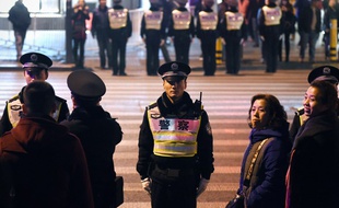 La police protège les piétons qui veulent traverser la route en 2015, dans la ville de Shanghaï.