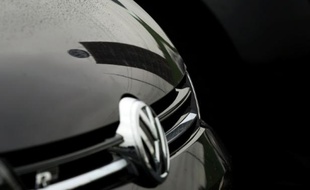 Le logo du constructeur automobile allemand Volkswagen se reflète sur une voiture Volkswagen, près du siège du groupe, à Wolfsburg (centre de l'Allemagne), le 8 octobre 2015