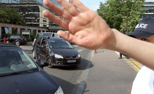 Des voitures de police arrivent devant le siège de la Direction centrale du renseignement intérieur (DCRI) à Levallois-Perret le 10 mai 2011, après un coup de filet dans le milieu islamiste français en région parisienne.