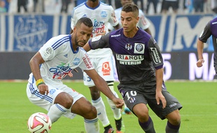 Le Marseillais Alaixys Romao (à gauche) à la lutte avec le Toulousain Wissam Ben Yedder lors du match de Ligue 1 entre l'OM et le TFC, le 19 octobre 2014 au stade Vélodrome de Marseille.