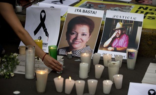 En mai 2017, des passants allument des bougies pour rendre hommes aux journalistes tués au Mexique, Miroslava Breach, à gauche et Javier Valdez lors d'une manifestation contre les assassinats de journalistes dans ce pays particulièrement dangereux pour les reporters.