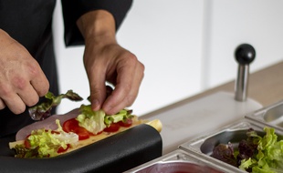 La machine à sandwichs coupe et maintient le pain ouvert.