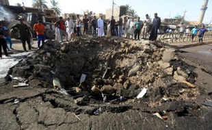 Photo prise le 18 juillet 2015 du cratère formé par l'explosion d'une voiture piégée revendiquée par l'EI dans la ville à majorité chiite de Khan Bani Saad au nord de Bagdad