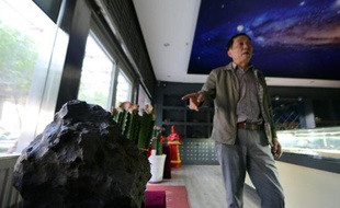 Tong Xianping, 50 ans, montre une des pièces maîtresses de sa collection de météorites, le 19 septembre 2014, dans son espace d'exposition à Urumqi, capitale de la vaste région désertique du Xinjiang, dans l'ouest de la Chine