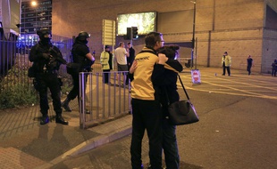Des spectateurs du concert d'Ariana Grande sous le choc après le probable attentat qui a frappé une salle de concert de Manchester, le 22 mai 2017.
