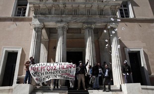 Des militants "antiautoritaires" déploient une bannière après avoir réalisé un brève incursion au Parlement grec à Athènes, le 1er avril 2015, en solidarité avec des prisonniers en grève de la faim