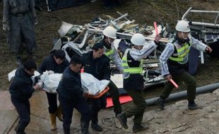 Des militaires emportent le corps d'une victime du crash aérien le 6 juin 2015 à Tapei