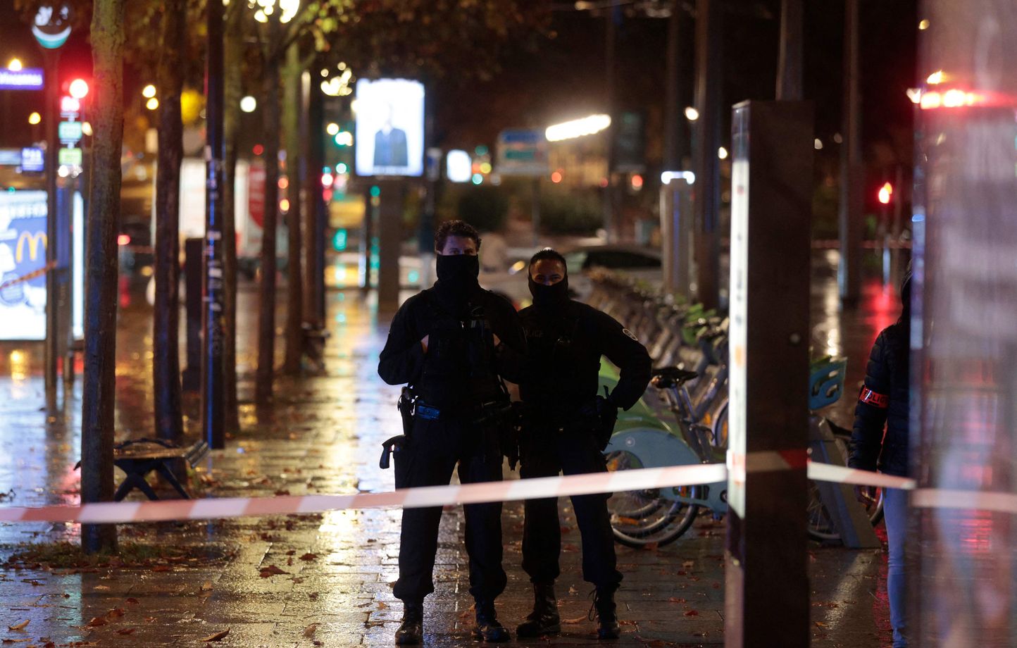 Police officers stand in the street as a driver was fatally shot by a police officer during a refusal to comply, in Paris, on October 14, 2022. - This shot "hit the driver who died," said the judicial source. Two investigations were opened: one for intentional homicide by a person holding public authority, entrusted to the "police of the police", and the second for attempted murder of a person holding public authority, carried out by the judiciary police, said the judicial and police sources.