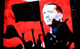 Des partisans d'Erdogan devant un écran diffusant son portrait lors d'un rassemblement à Ankara le 20 juillet 2016