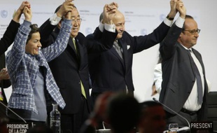 Laurent Fabius (c), Ban Ki Moon et François Hollande (d) à l'annonce de l'adoption de l'accord sur le climat au Bourget, le 12 décembre 2015