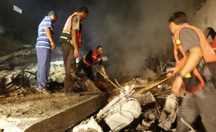 Des Palestiniens dans les ruines d'une maison détruite par un tir israélien le 19 août 2014 à Gasa