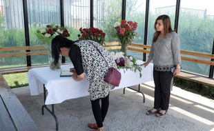 Deux femmes signent le registre de condoléances après la mort de quatre touristes, le 31 juillet 2018.