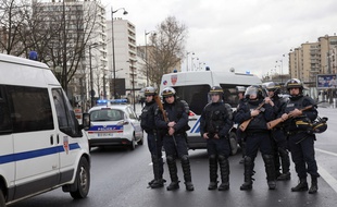 French police officers arrive to take up positions near Porte de Vincennes in Paris on January 9, 2015, after at least one person was injured when a gunman opened fire at a kosher grocery store and took at least five people hostage, sources told AFP. The attacker was suspected of being the same gunman who killed a policewoman in a shooting in Montrouge in southern Paris on January 8. AFP PHOTO / LOIC VENANCE