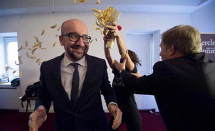 Le Premier ministre belge, Charles Michel, est aspérgé de mayonnaise et reçoit des frites jetées par des féministes belges (ex-Femen) lors d'une conférence à Namur le 22 décembre 2014