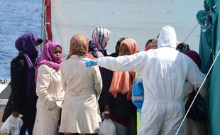 La Croix Rouge italienne aide des migrants à leur arrivée à Messine en Sicile le 15 avril 2015