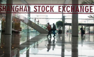 This photo taken on October 16, 2014 shows people shows people walking inside the Shanghai Stock Exchange building in Shanghai. When the Shanghai and Hong Kong stock exchanges "connect" on November 17 it will open multi-billion-dollar channels for investors to play both markets, but some Chinese punters say it looks more like a bad trade. AFP PHOTO / JOHANNES EISELE