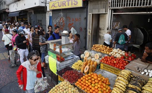 Des Vénézuéliens font la queue pour acheter à manger, malgré la coupure d'électricité qui les empêche d’utiliser leur carte bancaire.