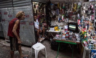 Un homme regarde le match du Mondial Pays-Bas-Espagne sur une télévision d'un kiosque à journaux à Rio de Janeiro, le 13 juin 2014