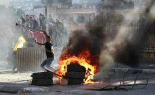 Un jeune Palestinien lance une pierre contre les forces de sécurité israéliennes, le 6 octobre 2015 à Bethléem