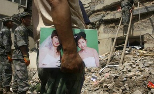 Un homme attend des nouvelles de sa femme, disparue dans des glissements de terrain dans la région de Gansu, en Chine, le 9 juillet 2010.