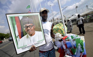 Un homme vend le 28 mai 2015 dans les rues d'Abuja une photo encadrée de Mohammadu Buhari et des drapeaux de son parti
