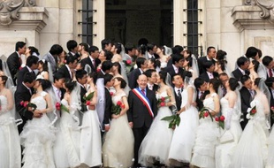 Des couples chinois tout juste mariés posent le 7 mai 2009 devant la mairie de Tours avec le maire de l'époque, Jean Germain