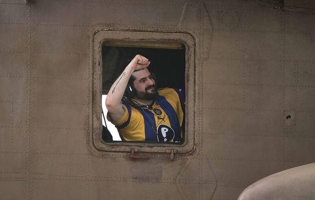 Poing levé, Ziv Berman, un des otages israéliens, s’apprête à atterrir au Sheba Medical Center de Ramat Gan. Il porte ce qui semble être un maillot du Maccabi Tel-Aviv, dont il est fan.