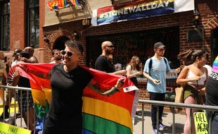 Une femme pose devant le Stonewall inn, à New York, lieu des mythiques émeutes entre communauté LGBT et policiers, en juin 1969.