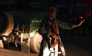 Un policier afghan bloque une route près du Park Place à Kaboul le 13 mai 2015 après une attaque