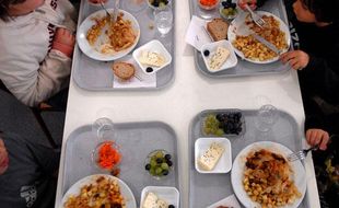 Des enfants mangent à la cantine. Illustration repas cantine.